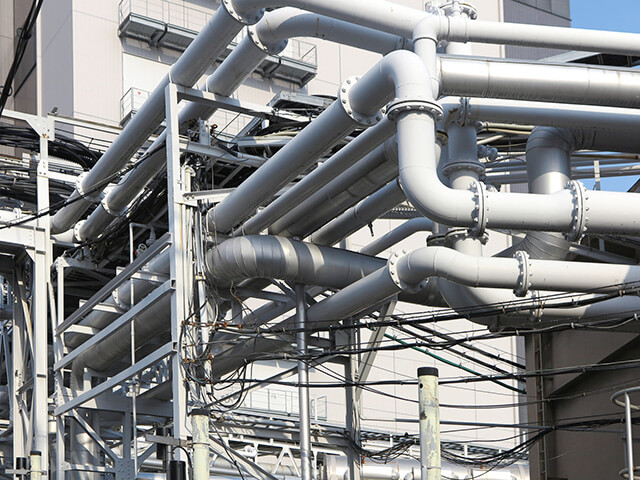 プラント施設内に整然と、かつ複雑に張り巡らされたシルバーの太い配管群。